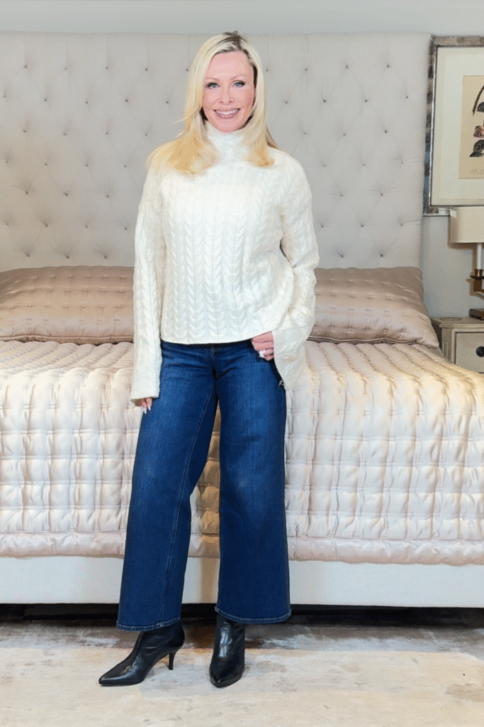 Over 50 fashion, beauty and fitness blogger wearing wide leg jeans with  a cozy sweater.