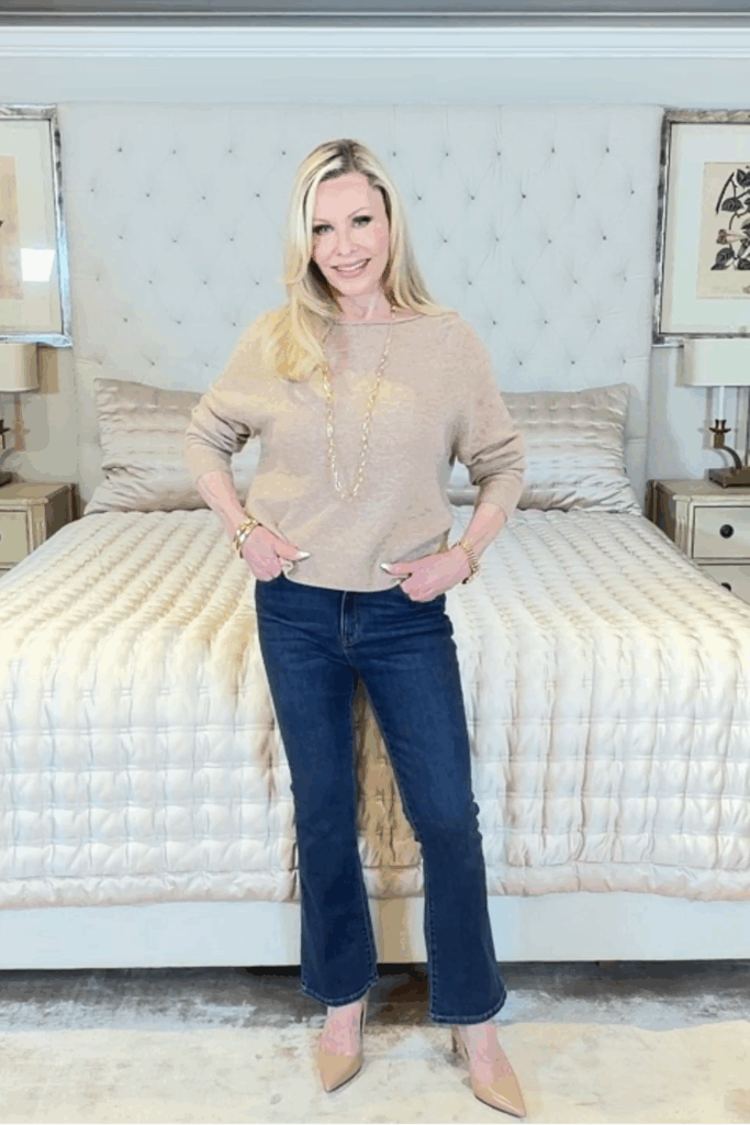 Classic camel Quince cashmere sweater paired with dark-wash kick-flare jeans for a timeless casual outfit.